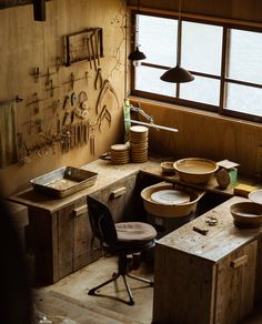 an old workbench with lots of wooden bowls and tools hanging on the wall