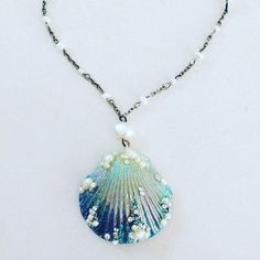 a necklace with a shell and pearls on it