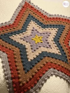 a crocheted star is hanging on the wall