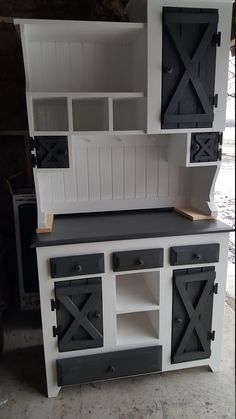 a white and black kitchen cabinet with sliding doors