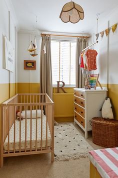 a baby's room with yellow walls and furniture