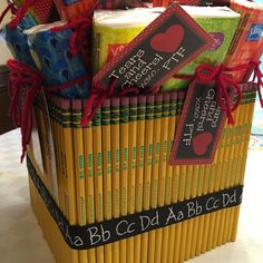 a large stack of books wrapped in yellow paper with red ribbon and tags on them