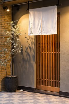 a potted plant sitting in front of a door with two white towels hanging from it's side