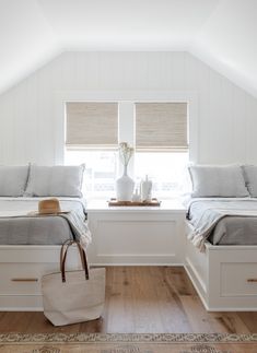 two beds in a room with white walls and wooden floors, one has a tote bag on the floor