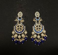 ROYAL BLUE CHANDBALI EARRINGS - WOMEN'S TRADITIONAL MEENAKARI JEWELRY Elegant set of earrings with beautiful blue Meenakari work. A versatile pair of earrings with royal blue & Gold Meenakari, Kundan and Pearl drop. The engraved traditional design adds an artisanal touch to the earrings. Details: Handcrafted Jewelry Metal: Metal Alloy, Gold Plated Stone:  Meenakari, Pearls &  Blue Gems Style: Contemporary yet Traditional Closure:  Push back clasp B Anu Designs jewelry pieces can be customized in Blue Round Meenakari Jewelry, Blue Temple Jewelry Jhumkas Gift, Blue Dangle Earrings For Festivals, Blue Dangle Danglers For Festivals, Blue Temple Jewelry Chandbalis With Latkans, Blue Temple Jewelry Chandbalis For Festivals, Traditional Blue Jewelry With Matching Earrings, Blue Temple Jewelry Chandbalis For Diwali, Blue Jewelry With Latkans For Diwali