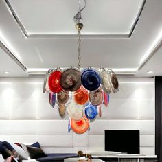 a living room filled with furniture and lots of plates hanging from the ceiling above it