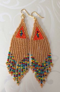 Handmade beaded long beige and multicolored seed bead earrings. Stunning handmade beaded earrings made with beige, orange and super bright multicolored 11/0 seed beads. The earrings have long flowing multicolored fringe. The french hook earwires and findings are sterling silver. These gorgeous Cheyenne style earrings are super long and brush your shoulders ever so slightly. Great for daywear and stunningly beautiful for the night out. Earrings measure approximately 4.5 inches including ear wires Brown Dangle Beaded Earrings With Tiny Beads, Beaded Beige Dangle Jewelry, Colorful Beaded Brown Earrings For Beach, Bohemian Beaded Necklaces With Colorful Beads In Beige, Brown Round Beads Earrings For Beach, Brown Beaded Earrings For The Beach, Beach Beaded Earrings With Colorful Beads, Brown Round Beaded Earrings For Beach, Beige Beaded Dangle Jewelry