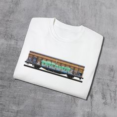 Our Dreamer print features hand-drawn graffiti on an old freight train. It's one for the dreamers and would make a great gift for any graffiti enthusiast.  This unisex ultra-cotton tee is made with quality cotton construction; the shoulders are taped for a good upper-body fit; and there are no side seams, ensuring a clean, unbroken flow and reducing fabric waste. The collar has ribbed knitting for improved elasticity. 100% US cotton* (fiber content may vary for some colors Medium fabric (6.0 oz/ Unisex Graffiti Print Crew Neck T-shirt, Crew Neck Cotton Sweatshirt With Graffiti Print, Cotton Crew Neck Sweatshirt With Graffiti Print, Cotton Sweatshirt With Graffiti Print In Relaxed Fit, Freight Train, Fabric Waste, Body Fit, Upper Body, Czech Republic