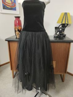 It would be worth finding the occasion to wear this fabulous after five dress. I'm thinking a 18th or 21st birthday. The dress is from the 1980s and is missing it's maker label but is very well made. The bodice is figure hugging, strapless and is boned ( giving it structure and has a dropped waist. The gathered skirt section has a double layer tuile overlay with scattered bows and diamontes and reaches low  calf length. The underskirt is in a polyester tafetta rayon. There is a back nylon zip. T Vintage Tulle Skirt Dress For Party, Vintage Tulle Dress For Party, After Five Dresses, Bodice Top, Hip Openers, Evening Cocktail, 1980s Dresses, Cocktail Evening Dresses, Gathered Skirt