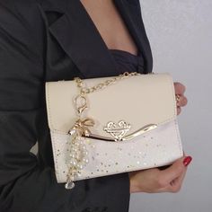 "Champagne Evening Clutch designed to be worn on the shoulder or in the hand long gold chain to wear on the shoulder internal mobile phone pocket inside zip pocket with external quick release decorative pearl beads, crystal and gold bow key ring the bottom of the bag is made up of an extra layer that helps keep its shape MATERIALS: faux leather high quality vegan external quick release decorative pearl beads, crystal and gold bow key ring DIMENSIONS: Width: 8.0\" / 20 cm Height: 6.5\" / 16 cm Side: 3.0\" / 7 cm Length of chain (round)  43.3\" / 110 cm Questions or additional photos? Just ask.💕 Possible express delivery within 4-10 days. Cost from 25 dollars. Etsy: https://www.etsy.com/shop/gorgeouslily Facebook :https://www.facebook.com/lilly.yavorskaya Instagram:https://www.instagram.com Wedding Party Bags, Bridal Clutch Bag, Prom Bag, Clutch Bag Wedding, Bridal Purse, Beige Handbags, Festival Earrings, Sparkly Wedding, Beaded Evening Bags