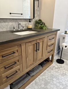 a bathroom with a sink, mirror and towel rack on the counter top in front of it