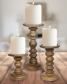 three candles sitting on top of a wooden table