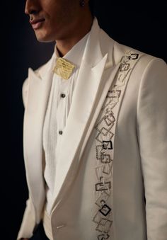 Brick by Brick Tux | Jatin Malik Showcasing an ivory suede tuxedo highlighted by shoulder pleating and exquisite hand-embroidered details. This elegant outfit is paired with a matching pintuck shirt and black tapered trousers, creating a sophisticated and polished look. Included in purchase: Tuxedo, Shirt, Trousers Product Specification Color: White Fabric: Suede Occasion: Engagement, Wedding, Bridal, Reception Style: Tuxedo, Shirt, Trousers Care: Dry Clean Work: Hand Embroidery, Pintuck Customization options:Can be customized in any color or style Note: A stylist will contact you to confirm measurements after your order is placed.Estimated delivery time: 4 -6 weeks (Variation in color, fabric & detail is possible. Model images are only representative.) This can be customized in any color, Jatin Malik, Embroidered Tuxedo, Ivory Tuxedo, Pintuck Shirt, Reception Cocktail, Brick By Brick, Indian Men, Tuxedo Pants, Tuxedo Wedding