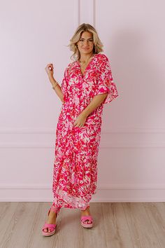 - Your style will blossom like a wildflower with this breezy dress! - Lightweight material with a pink hued floral print - A built-in partial skirt lining ending thigh length - A v-cut neckline with two hidden hook and eyes for additional coverage - Loose short sleeves - A cinched waistline with an elastic back - A flowy yet flattering silhouette that ends in a straight maxi length hemline Measurements S : Bust 34", Hip 36", Length 52", Sleeve Length 16", Waist 26-30". M : Bust 36", Hip 38", Len Flowy Tropical V-neck Dress, Flowy V-neck Tropical Dress, Pink Floral Print V-neck Maxi Dress, Breezy Pink V-neck Maxi Dress, Pink V-neck Maxi Dress With Vibrant Print, Pink Floral V-neck Dress For Brunch, Pink Breezy Beach Cover-up Dress, Pink Maxi Dress With Vibrant Print For Beach, Breezy Pink Dress For Beach Cover-up