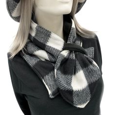 a mannequin head wearing a black and white plaid scarf with a hat on it