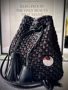 This stylish black bag is hand crocheted from high quality raffia. It is perfect for all occasions and offers both functionality and fashion. The bag has an elegant and unique look that complements any outfit. Ideal for everyday use or special occasions. Chic Braided Bucket Shoulder Bag, Luxury Crochet Shoulder Bag With Woven Leather, Luxury Crochet Woven Leather Shoulder Bag, Luxury Crochet Leather Woven Shoulder Bag, Chic Woven Bucket Crochet Bag, Chic Woven Crochet Bucket Bag, Chic Braided Straw Bag, Braided Bucket Crochet Bag For Travel, Luxury Black Straw Bag For Everyday Use