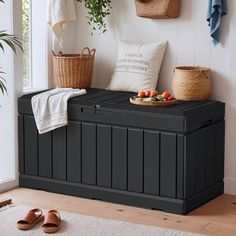 a black storage bench sitting next to a window