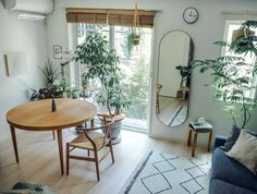 a living room filled with furniture and a large mirror on the wall next to a wooden table