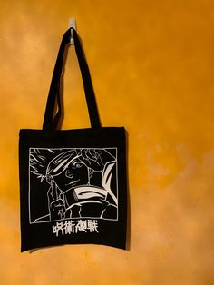 "Everyone's favourite, and strongest Jujutsu sorcerer. Printed using vinyl on durable, black tote bag. Image has been edited. Disclaimer: I do not own Jujutsu Kaisen. Dimensions: 13.3\" X 15.3\" 9.4\" straps Does not ship to Germany." Black Bags With Graphic Print For Streetwear, Black Graphic Print Bag For Streetwear, Black Graphic Print Bags For Streetwear, Black Rectangular Canvas Bag With Graphic Print, Black Rectangular Bag With Anime Print, Black Canvas Tote Bag With Graphic Print, Black Graphic Print Canvas Tote Bag, Black Shoulder Bag With Graphic Print For Daily Use, Black Graphic Print Shoulder Bag For Daily Use