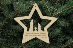 a christmas ornament hanging on a pine tree with the words, behold, the lambs of god who takes care of the son of the world