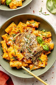 two bowls filled with pasta and vegetables on top of a table