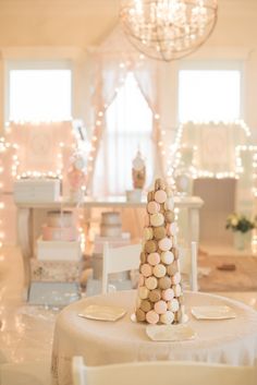 a table topped with a white plate covered in candies next to a chandelier