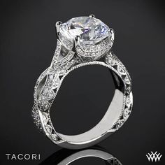 a white gold engagement ring with an intricate filigree design