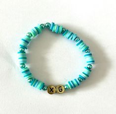 XG K-pop girl group beaded bracelet. Green, blue and gold, fun and lightweight. perfect for ALPHAZ! Adjustable Blue Name Bracelet With Colorful Beads, Trendy Blue Stretch Bracelet With Letter Beads, Trendy Blue Name Bracelet With Letter Beads, Adjustable Blue Kpop Bracelets, Casual Blue Beaded Name Bracelet, Kpop Style Blue Beaded Bracelets As Gift, Blue Kpop Style Beaded Bracelet Gift, Blue Name Bracelet With Colorful Round Beads, Casual Blue Name Bracelet With Round Beads