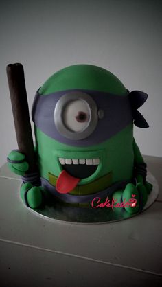 a green and black cake with an angry looking character holding a baseball bat in it's hand