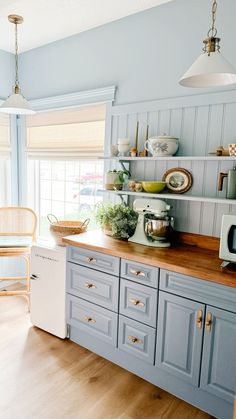 a kitchen with blue cabinets and wooden counter tops