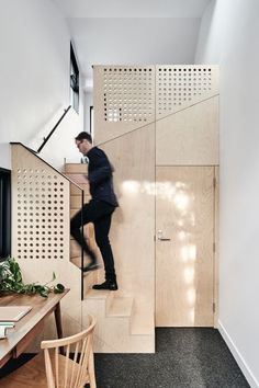 a man walking up some stairs in a house