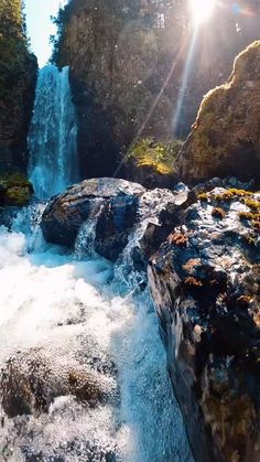 the sun shines brightly over a waterfall