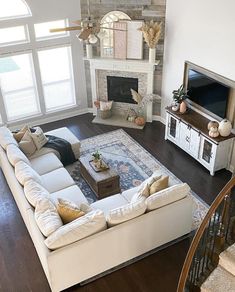 a living room filled with furniture and a flat screen tv on top of a wooden floor