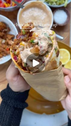 a person holding up a wrap filled with food