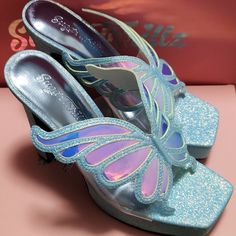 Nwt Sugar Thrillz Pixie Glitter Heels, Size 7... You Just Have To Spread Your Wings. Fly Off Wearing These Open Square-Toe Heels That Have A Glittery Construction And Holographic Butterfly Straps. Light Blue In Colour, Vinyl Uppers, And Rubber Soles. Reasonable Offers Welcome Fyi: Measurements Are Available Upon Request. No Returns Are Based On Size. Shoes And Sizes Are Clearly Described And Photographed. Please Ask Any Questions Before Purchasing. Thank You! Light Blue Platform Heels With Pointed Toe, Spring Glitter Heels In Synthetic Material, Sequined High Heels In Synthetic Material, Synthetic Heels With Glitter Accents And Round Toe, Iridescent Round Toe Synthetic Heels, Iridescent Synthetic Heels With Round Toe, Glitter Closed Toe Heels For Spring, Spring Glitter Heels With Pointed Toe, Iridescent Synthetic Round Toe Heels