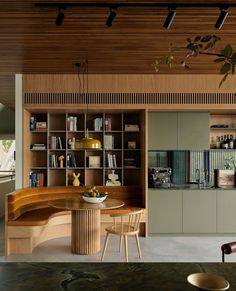 a dining room table and chairs in front of a bookshelf