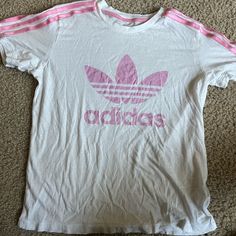 Size: Medium Color : Pink And White Brand: Adidas Condition: Never Worn It Looks Like That Because It Was In My Bin And Got Wrinkled But Other Than That Never Been Worn And In Good Condition No Stains And No Tears Material: Really Soft Adidas Three Stripes T-shirt For Spring, Summer Adidas Logo Top, Adidas Logo Summer Top, Basic Logo Print Top For Spring, Basic Spring Top With Logo Print, Adidas Three Stripes Summer Tops, Adidas Summer Tops With Three Stripes, Adidas Logo Tops, Trendy Adidas T-shirt With Letter Print