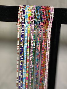 Each strand of glass seed beads is intricately designed, by hand, by placing each bead one-by-one on traditional cord. The strands of the Summer Collection vary in hues of pink,purple,blue, and green creating stunningly unique waist beads. The strands of beads are a traditional tie-on style and can be adjusted and sized to fit individual waists. For proper bead placement, first decide where you want your waist beads to fall on your body. Using a measuring tape measure in inches, selecting the ar Spiritual Multicolor Round Waist Beads, Hand-strung Heishi Beaded Necklaces, Pink Multi-strand Colorful Beaded Bracelets, Pink Multi-strand Colorful Beaded Bracelet, Pink Multi-strand Bracelets With Colorful Beads, Hand-strung Multicolor Round Beaded Necklaces, Colorful Heishi Beads For Festival, Festival Beaded Necklace With Round Beads, Spiritual Multicolor Waist Beads With Tiny Beads