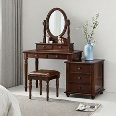 a bedroom scene with focus on the dressing table and stool, along with a vase filled with flowers