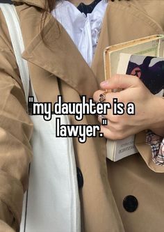 a woman wearing a trench coat and holding a book with the caption, my daughter is a lawyer