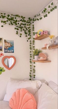 a bedroom with green ivy growing on the wall and white bedding, along with shelves filled with toys