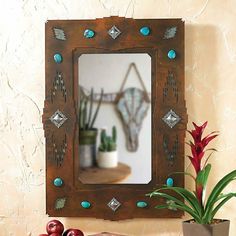 a mirror sitting on top of a table next to a potted plant