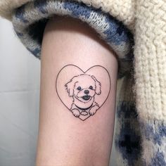 a small black and white dog in a heart tattoo