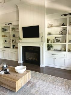 a living room filled with furniture and a flat screen tv mounted on the wall above a fireplace