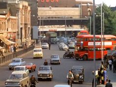 cars, buses and pedestrians on a busy city street