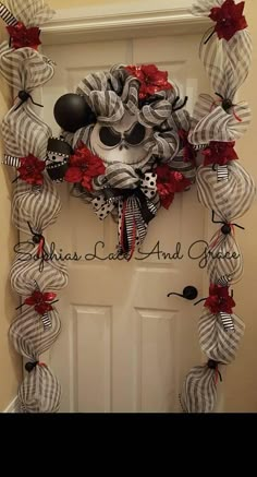 the front door is decorated with red, white and black ribbon wreaths for halloween