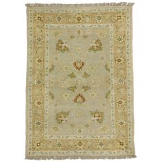 an antique rug with floral designs and fringes on the edges, in light green