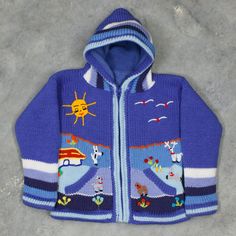 a child's blue jacket with cartoon animals on the front and back, sitting on concrete