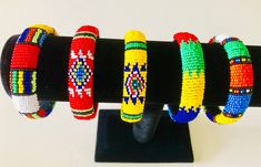 Solid Ethnic Bangle - Adjustable to fit most wrists. Ethnic Zulu Beadwork Bangle available in a variety of colour combinations. Produced by local crafters around Kwa-Zulu Natal region in South Africa. Our products are handcrafted therefore colour, design and size may vary slightly. Weight:  20g Length / Circumference:  24cm Diameter:  7.5cm Width:  1.5cm Traditional Multicolor Beaded Bracelets With Large Beads, Traditional Multicolor Beaded Bangle Bracelets, Traditional Multicolor Bracelets For Festivals, Traditional Multicolor Beaded Bracelets, Traditional Multicolor Festival Bracelets, Handmade Multicolor Cuff Bracelet For Festivals, Traditional Fair Trade Bracelets With Round Beads, Traditional Fair Trade Beaded Bracelets For Gifts, Traditional Multicolor Handmade Cuff Bracelet