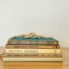 three books stacked on top of each other with bead balls in the middle and one sitting on top of them